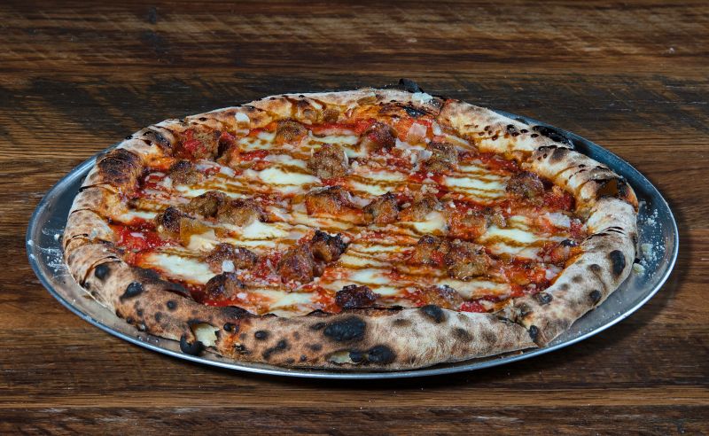 Mod Pizza meat lovers pizza loaded with sausage and bacon
